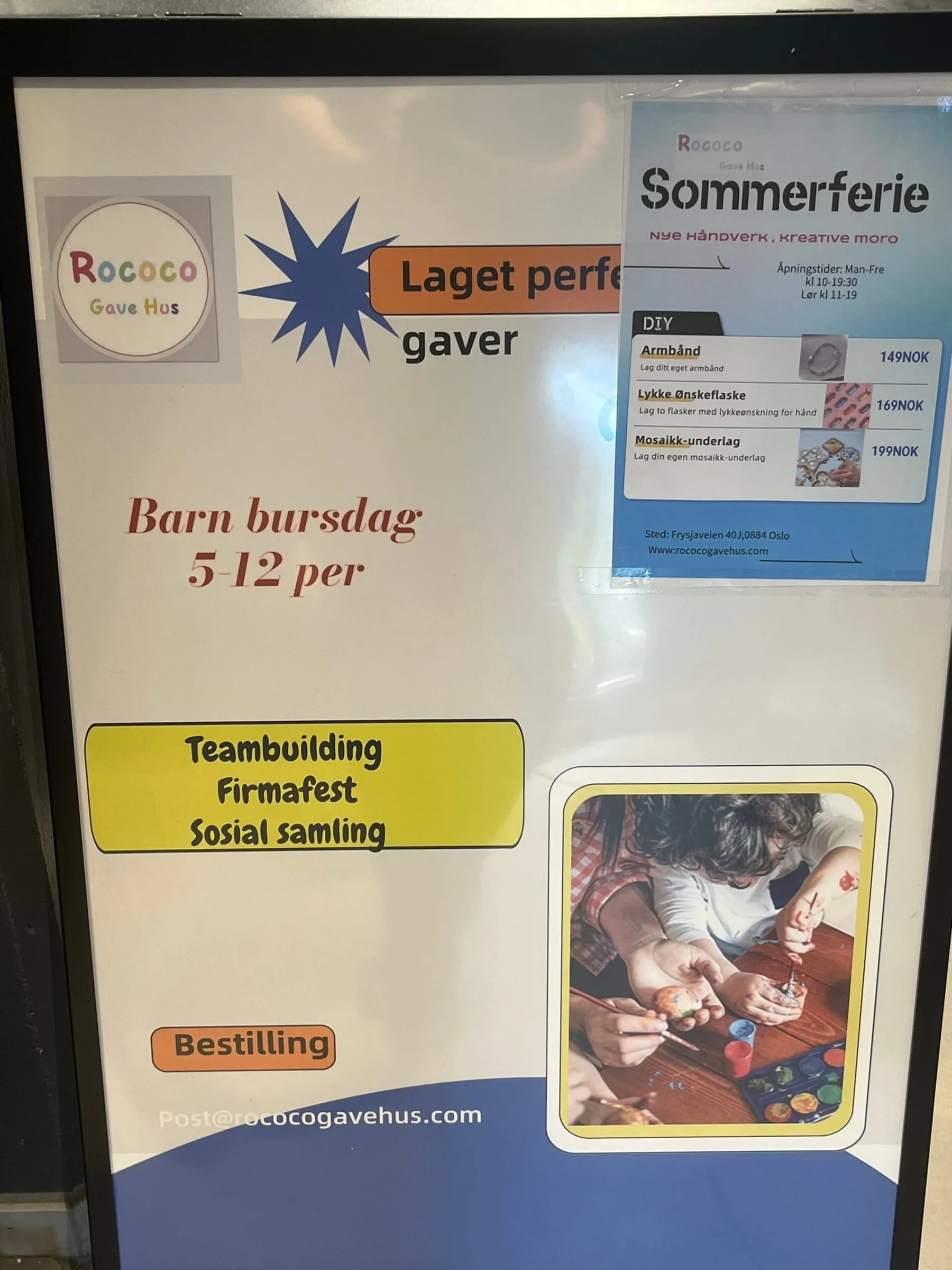 Signboard for Rococo Gave Hus with gift and workshop offers and a photo of a child painting